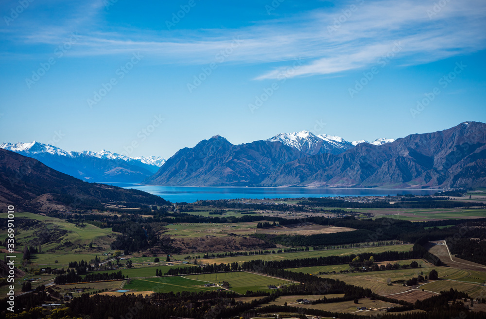 Stunning aerial image of the Wanaka fields with the snowy Mount Aspiring in the background on a sunny winter day, New Zealand