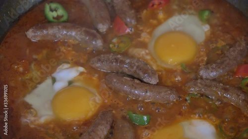 Close up shot of wiener sausages and egg on the grill slow motion