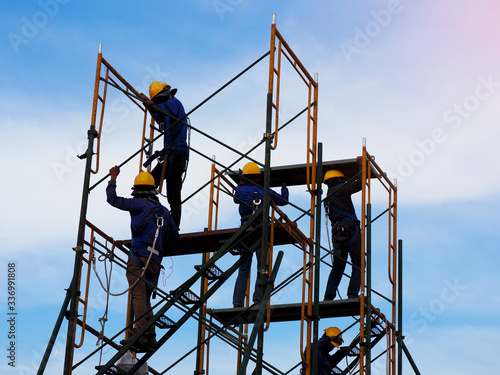 Construction workers working on scaffolding,Man Working on the Working at height with blue sky at construction site