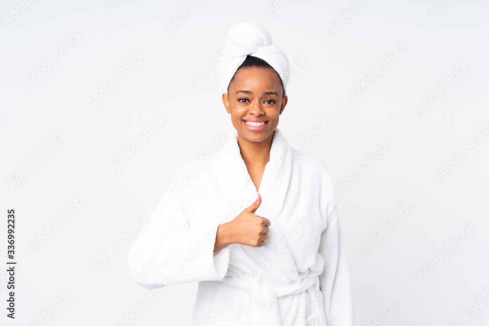 African american woman in a bathrobe over isolated background giving a thumbs up gesture African american woman in a bathrobe over isolated background giving a thumbs up gesture
