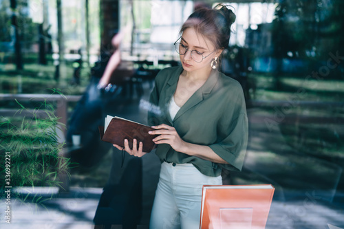 Pensive woman reading notebook in office