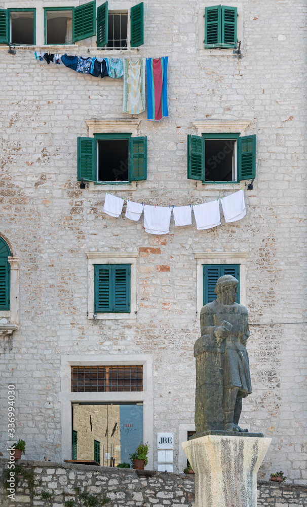 SIBENIK, CROATIA - 2017 AUGUST 18. Statue outside of Cathedral of Saint James of Šibenik, and laundry hanging out to dry.
