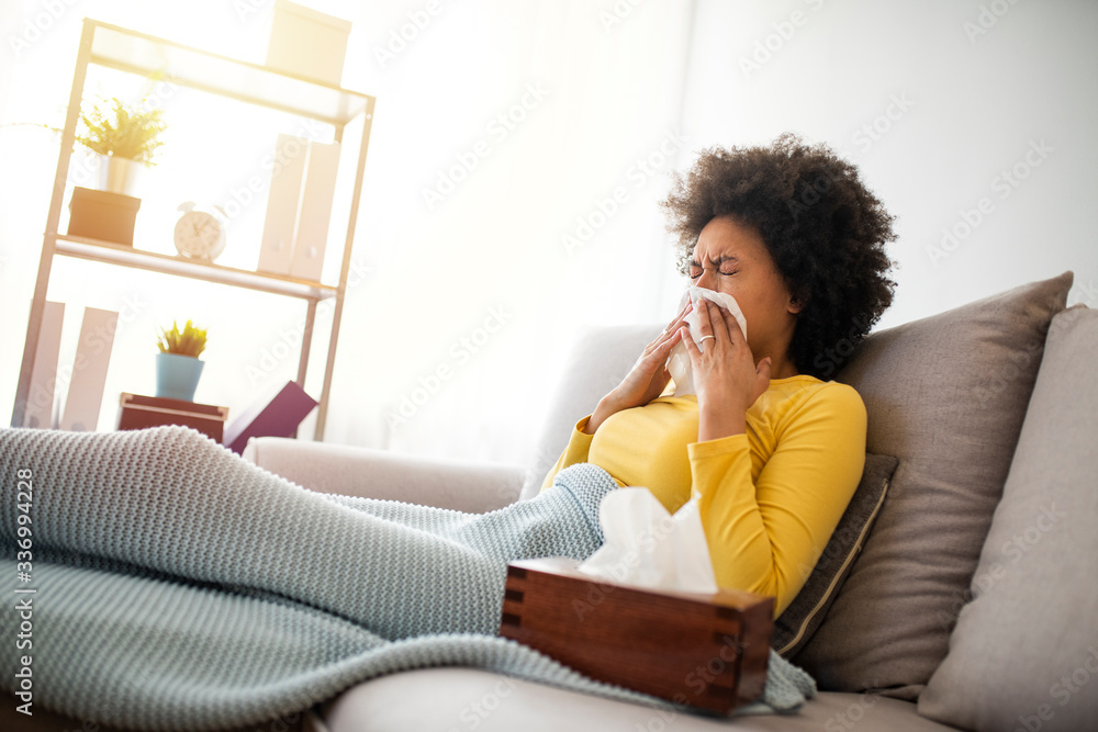 Sick Woman Covered With a Blanket Lying in Bed With High Fever and a Flu, Resting at Living Room. She Is Exhausted and Suffering From Flu. Sick Woman With Runny Nose Lying in Bed Sick Woman Covered With a Blanket Lying in Bed With High Fever and a Flu, Resting at Living Room. She Is Exhausted and Suffering From Flu. Sick Woman With Runny Nose Lying in Bed