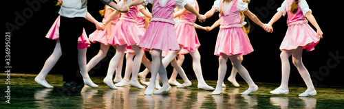Children dance on stage in elegant clothes 