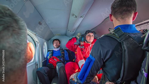 Group Of Skydivers Laughing And Preparing In Cockpit Of Plane Before Jump photo