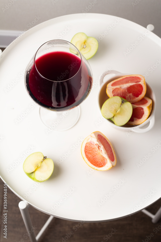 glass of red wine and fruits on a white table top view
glass of red wine and fruits on a white table top view