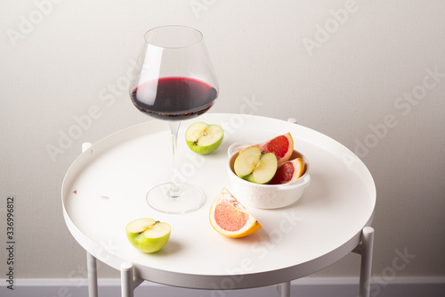 glass of red wine and fruits on the table 