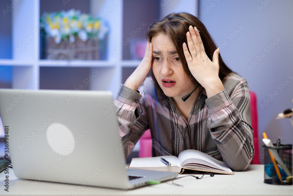 Shocked girl with laptop at home. Cute girl doing homework on computer. Modern online education, communication and technology concept Shocked girl with laptop at home. Cute girl doing homework on computer. Modern online education, communication and technology concept