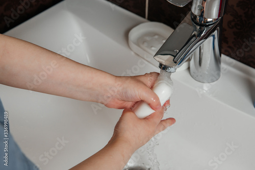 Baby washes his hands qualitatively with soap in the sink