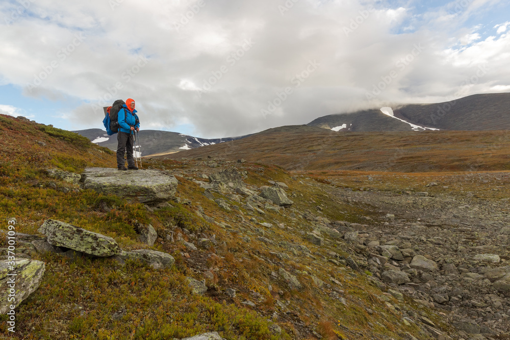 female hiker witt backpack at Kungsleden trail admiring nature of Sarek