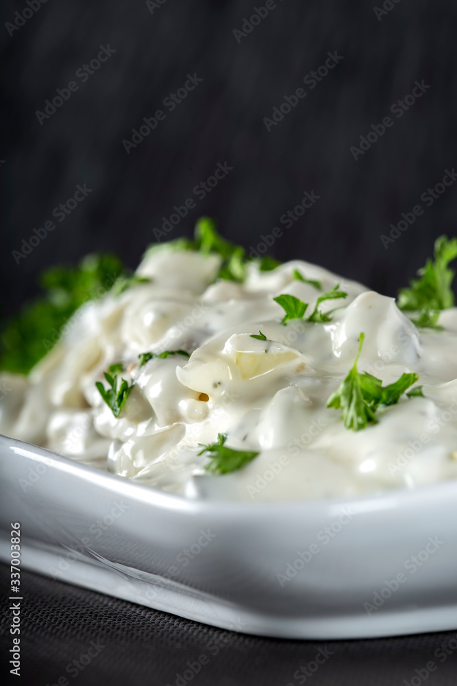 Salad of marinated fish with mayonnaise sauce and herbs