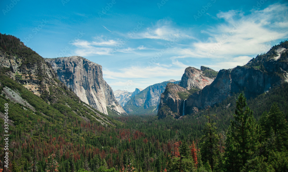 Yosemite National Park Valley from Tunnel View. The view looks eastward and includes surrounding features, such as El Capitan on the left, Half Dome on axis, and Bridalveil Fall on the right.