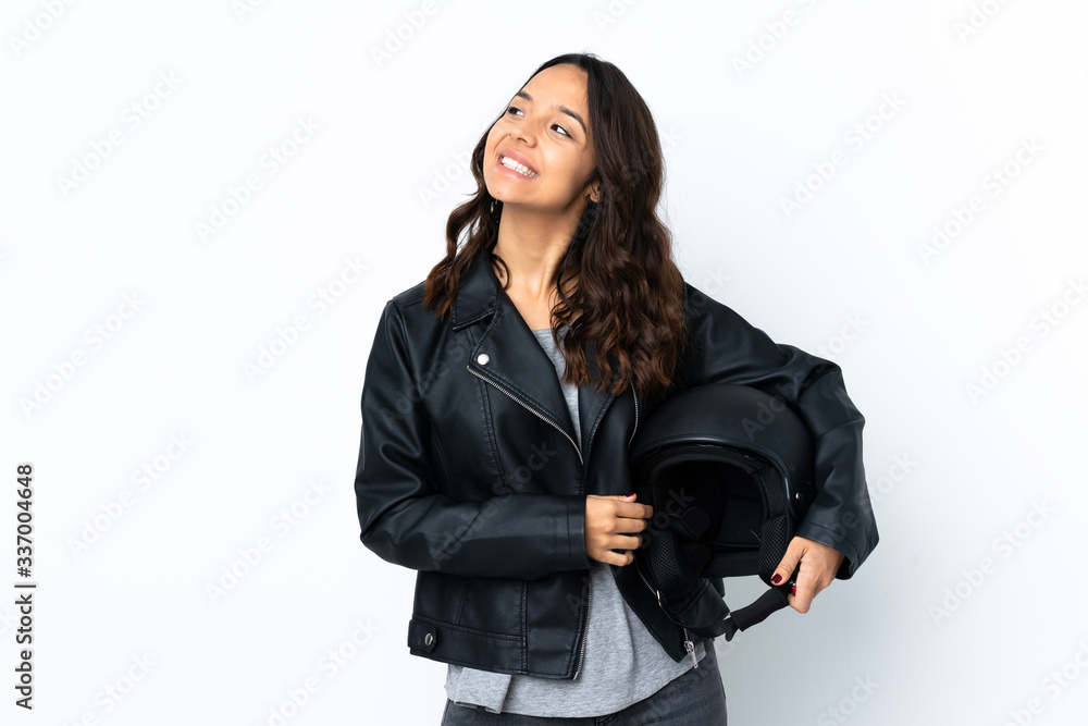 Young woman holding a motorcycle helmet over isolated white background thinking an idea Young woman holding a motorcycle helmet over isolated white background thinking an idea