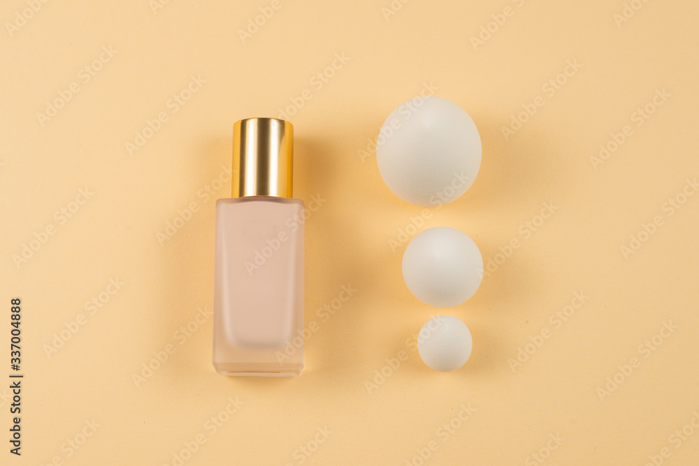 Small, medium and large  white beauty blender and makeup foundation on beige background.