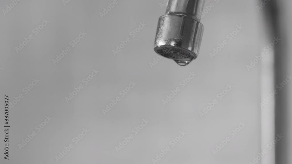 water droplets dripping down from a tap into a sink in the kitchen interior water droplets dripping down from a tap into a sink in the kitchen interior