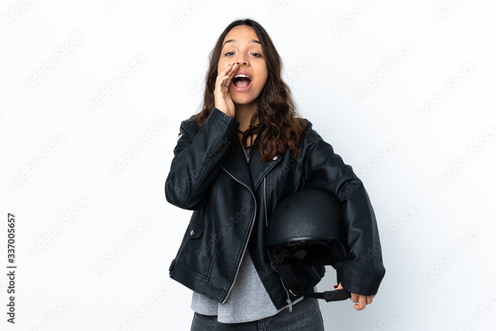 Young woman holding a motorcycle helmet over isolated white background shouting and announcing something Young woman holding a motorcycle helmet over isolated white background shouting and announcing something