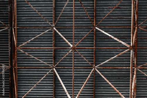 The roof of an industrial building made of iron pipes, a dark background