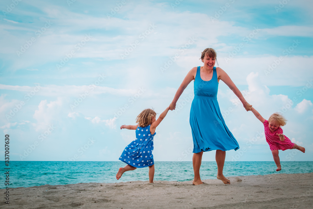mother with little daughters play on tropical beach mother with little daughters play on tropical beach
