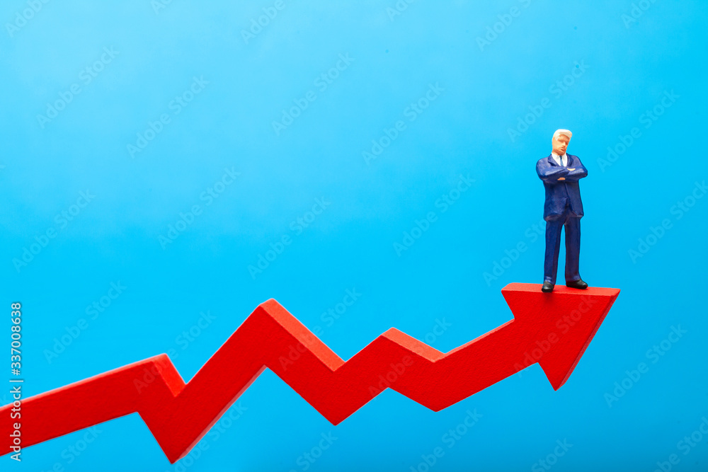 Businessman in suit stands on red growth arrow up on blue background. Copy space for text Businessman in suit stands on red growth arrow up on blue background. Copy space for text