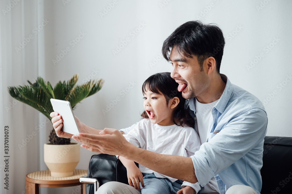 Father and daughter at home using a Tablet PC Father and daughter at home using a Tablet PC