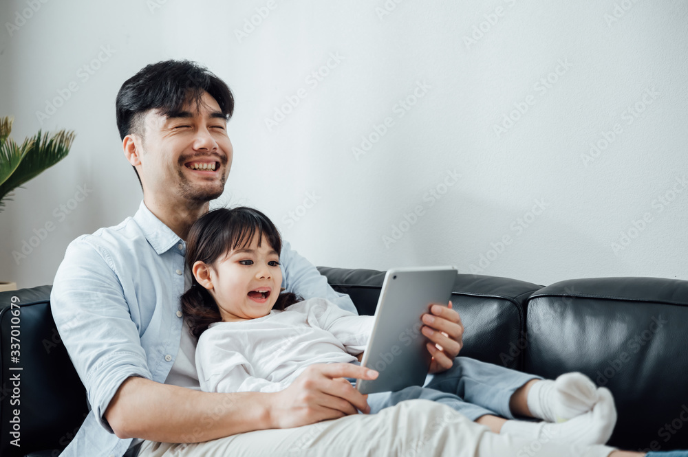 Father and daughter at home using a Tablet PC