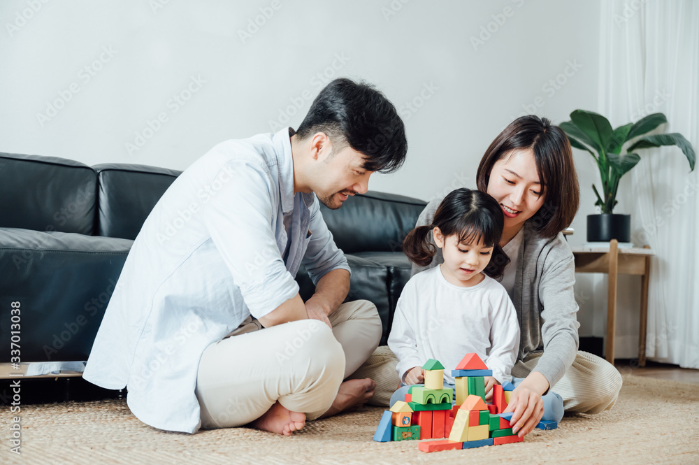 Mom and Dad and daughter at home building blocks Mom and Dad and daughter at home building blocks