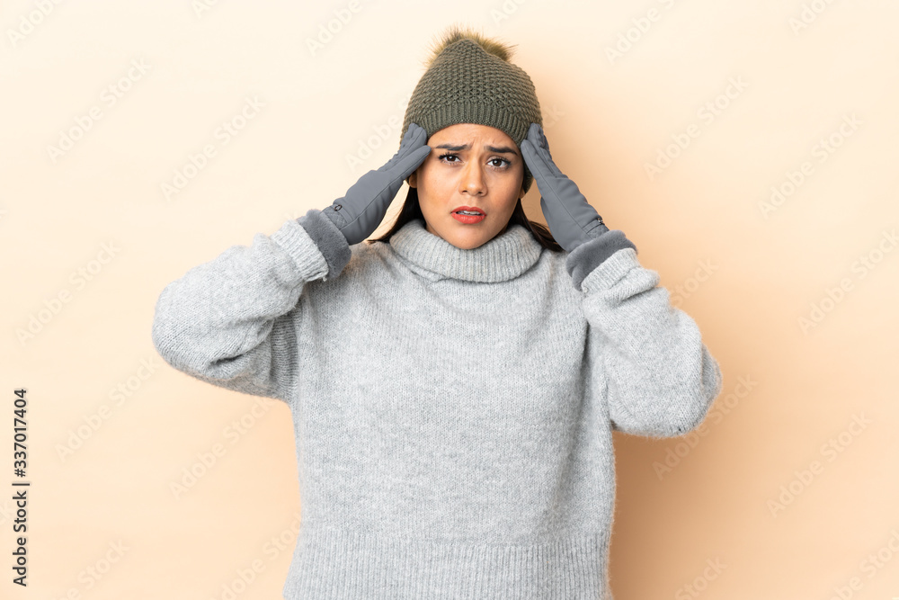 Young Colombian girl with winter hat isolated on beige background unhappy and frustrated with something. Negative facial expression Young Colombian girl with winter hat isolated on beige background unhappy and frustrated with something. Negative facial expression