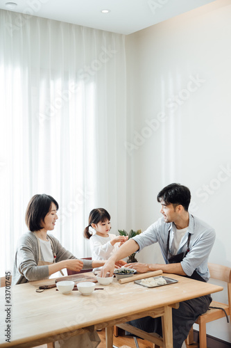 Mom and Dad and daughter at home dumplings
