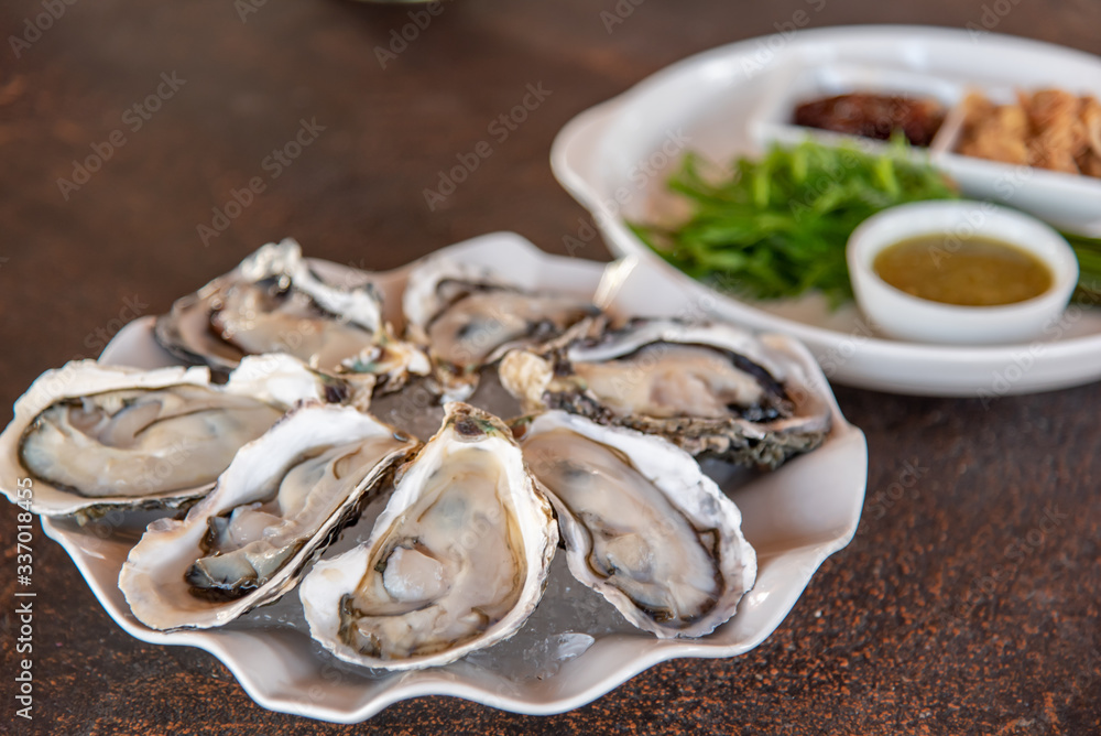 Fresh oysters in a lid on a white plate Fresh oysters in a lid on a white plate