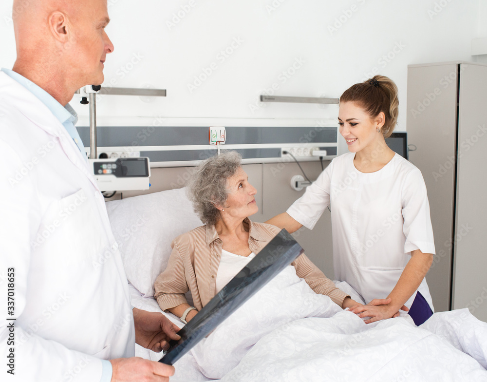 elderly patient receives support from a nurse while lying in a hospital bed. Caring for Elderly Patients elderly patient receives support from a nurse while lying in a hospital bed. Caring for Elderly Patients