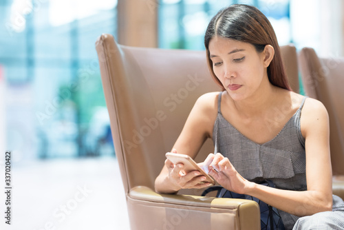 Free Download photo of young asian woman's hand holding smart phone typing on device lying on sofa at home. - GFXLoad