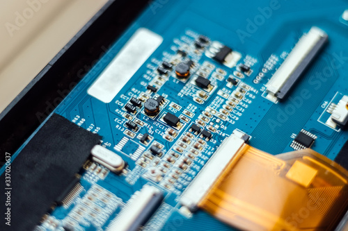 Part of a blue computer motherboard with same capacitors background. Selective focus. Closeup view