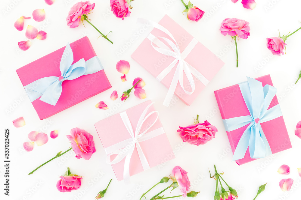 Obraz premium Floral composition of pink roses flowers and gifts on white background. Flat lay