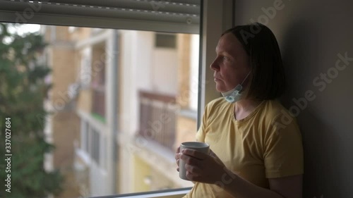 Woman in self-isolation during virus outbreak drinking coffee photo