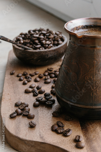 Turkish coffee pot and coffee beans on wooden board