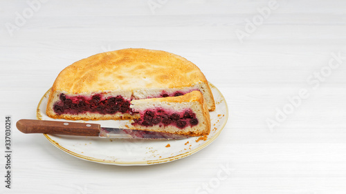 Homemade raspberry pie and sliced piece on white wooden table. Shallow focus. Copyspace.