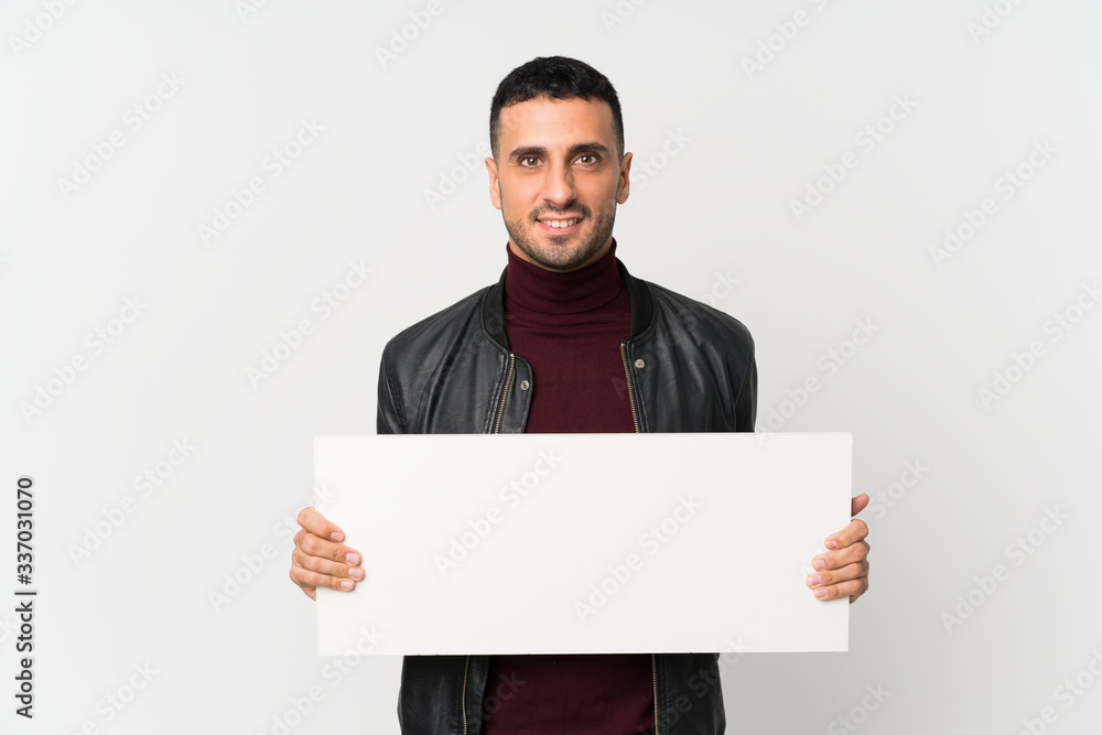 Young man over isolated white background holding an empty white placard for insert a concept Young man over isolated white background holding an empty white placard for insert a concept