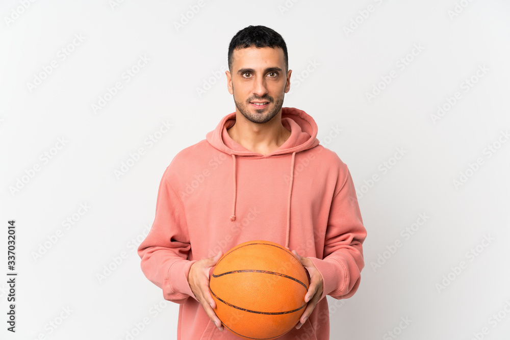 Young man over isolated white background with ball of basketball Young man over isolated white background with ball of basketball