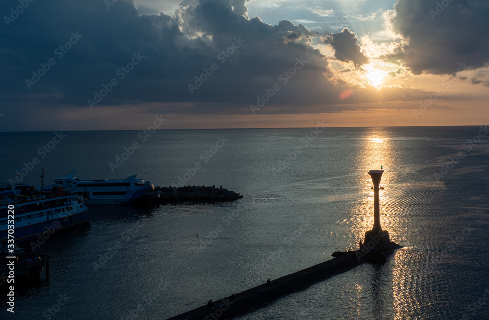 Lighthouse on seashore during beautiful sunset