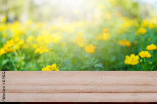 Wood table top on blur flower and green bokeh background
