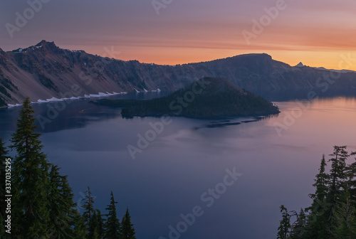 Spring landscape at dawn of Crater Lake with conifers  Wizard Island  and crater rim  Crater Lake National Park  Oregon  USA