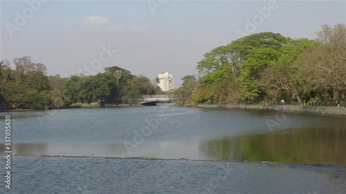 Lake side public park in summer evening. Garden footpath park lane illuminated by sunset sunlight. Red and orange color in landscape scene. Sun setting. Dhakuria lake Town Kolkata  India South Asia  photo