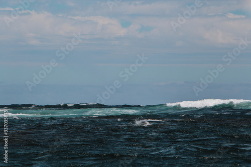Blue ocean with waves and rocks in Australia © elinasegall