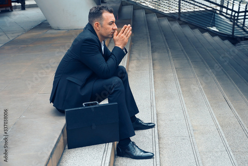 Businessman sit on the stairs and pray for apply job , layoff concept. photo