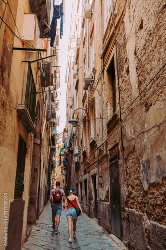 Couple holding hands, walks along the narrow street of Naples © NOWIK my stock