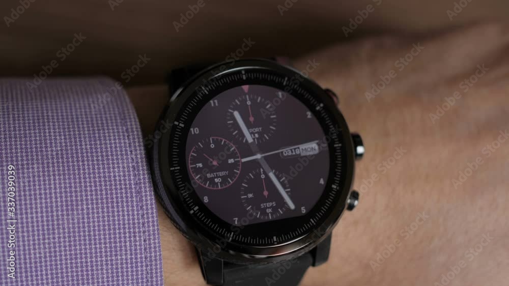 Businessman checks the time on a smartwatch. Close-up. Hands of guy wearing trendy smart watch.Modern gadget that lets you always stay connected to internet. Smart wrist watches. Businessman checks the time on a smartwatch. Close-up. Hands of guy wearing trendy smart watch.Modern gadget that lets you always stay connected to internet. Smart wrist watches.