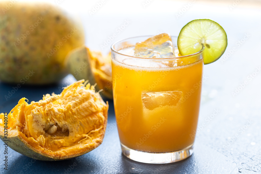 exotic fruit juice from Bel fruit or wooden Apple called in India Bel Ka Sharbat. cold fruit drink with ice on a blue background. natural detox. vitamins for immunity exotic fruit juice from Bel fruit or wooden Apple called in India Bel Ka Sharbat. cold fruit drink with ice on a blue background. natural detox. vitamins for immunity