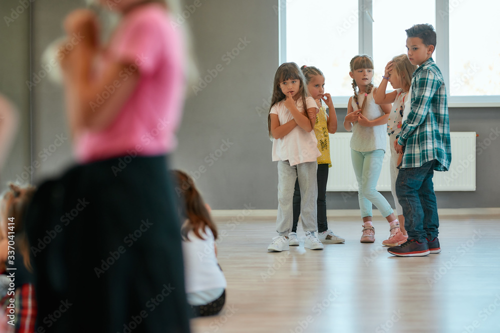Fototapeta premium Dance training. Group of children studying standing in the dance studio. Choreography class