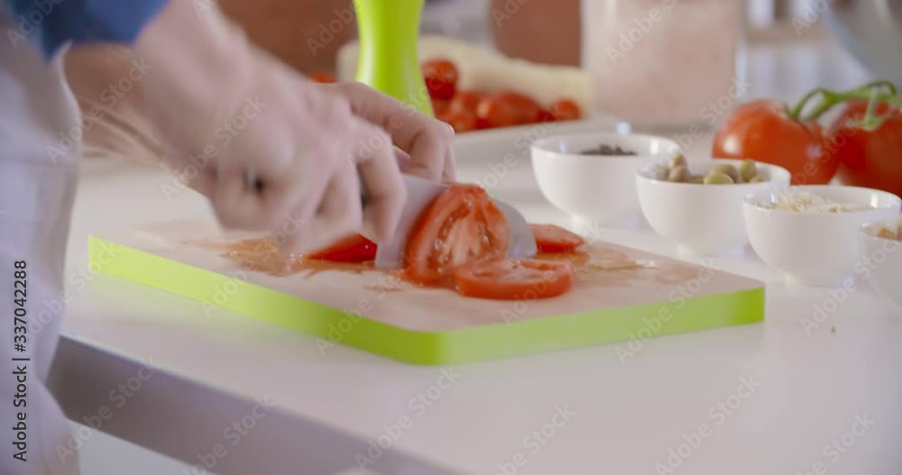 Detail of man's hand cutting tomatoes at home open space kitchen. Mediterranean healthy diet vegetables,tomatoes,salad. Modern love relationship,helping.4k video Detail of man's hand cutting tomatoes at home open space kitchen. Mediterranean healthy diet vegetables,tomatoes,salad. Modern love relationship,helping.4k video