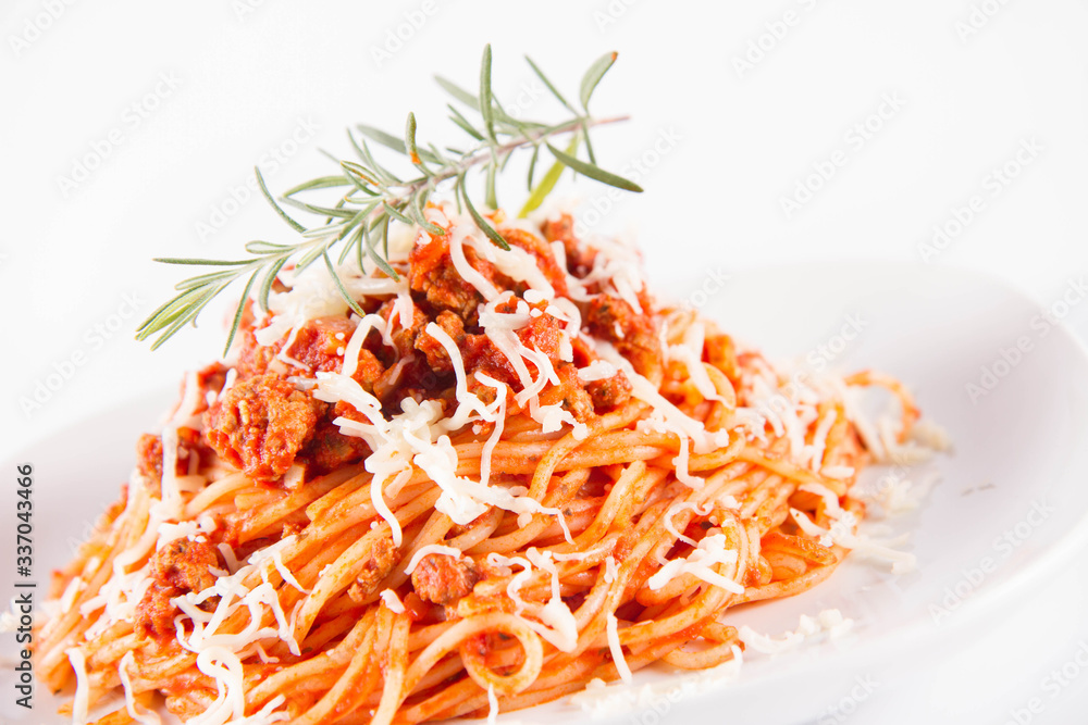 Spaghetti bolognese on a plate decorated with a rosemary twig and sprinkled with cheese Spaghetti bolognese on a plate decorated with a rosemary twig and sprinkled with cheese